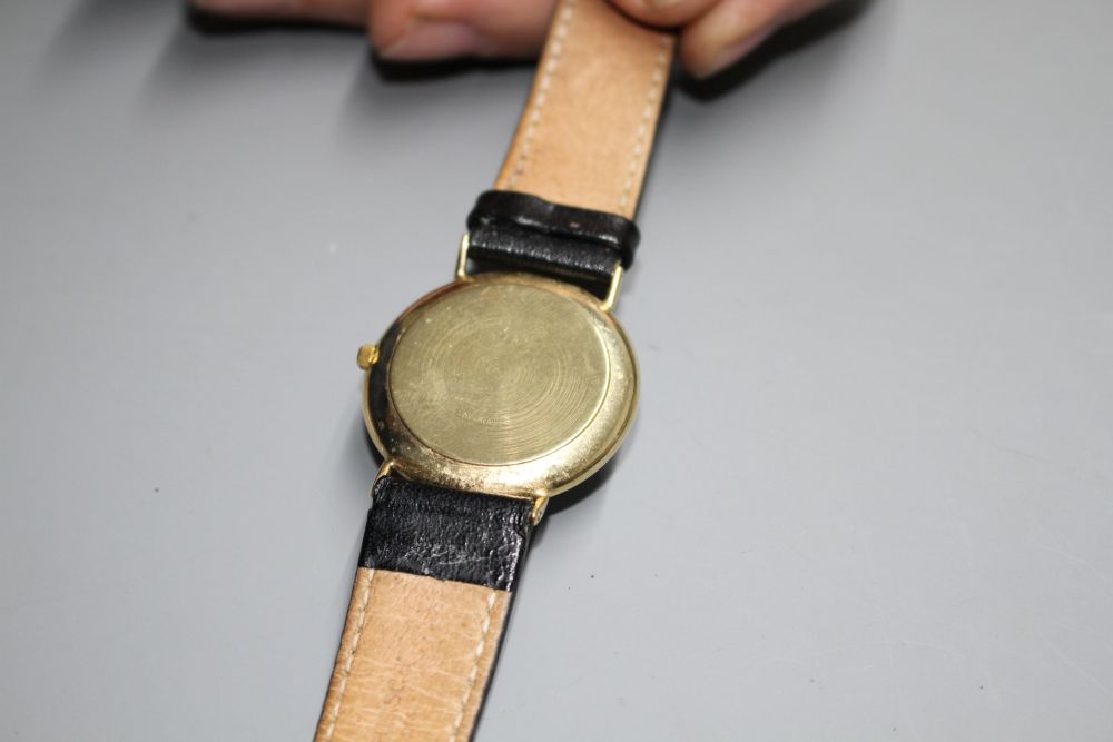 A gentlemans 9ct gold quartz? dress wrist watch, with Roman dial and date aperture, on associated leather strap.